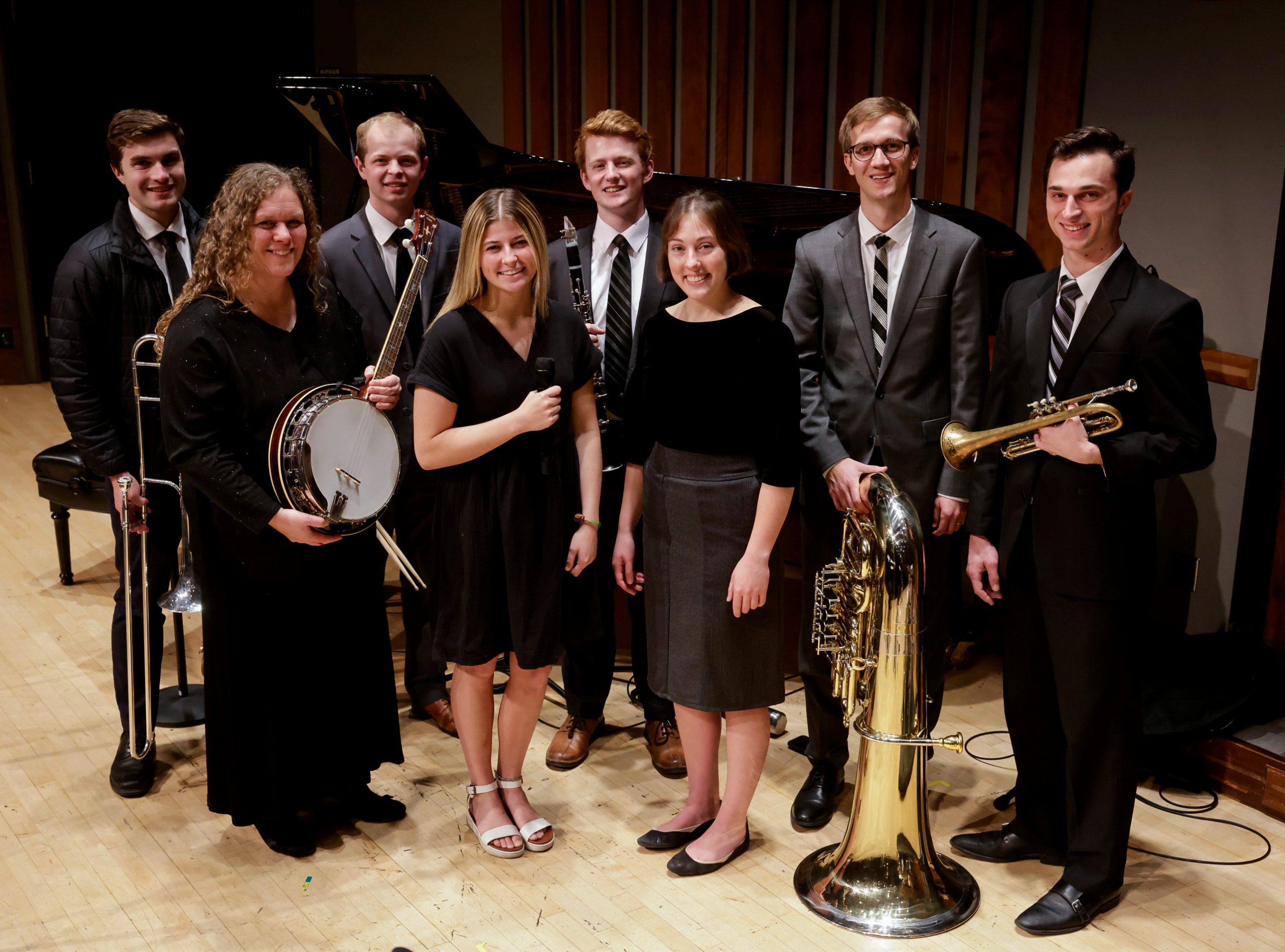 Jazz Legacy poses together with instruments in hand, wearing concert black attire.