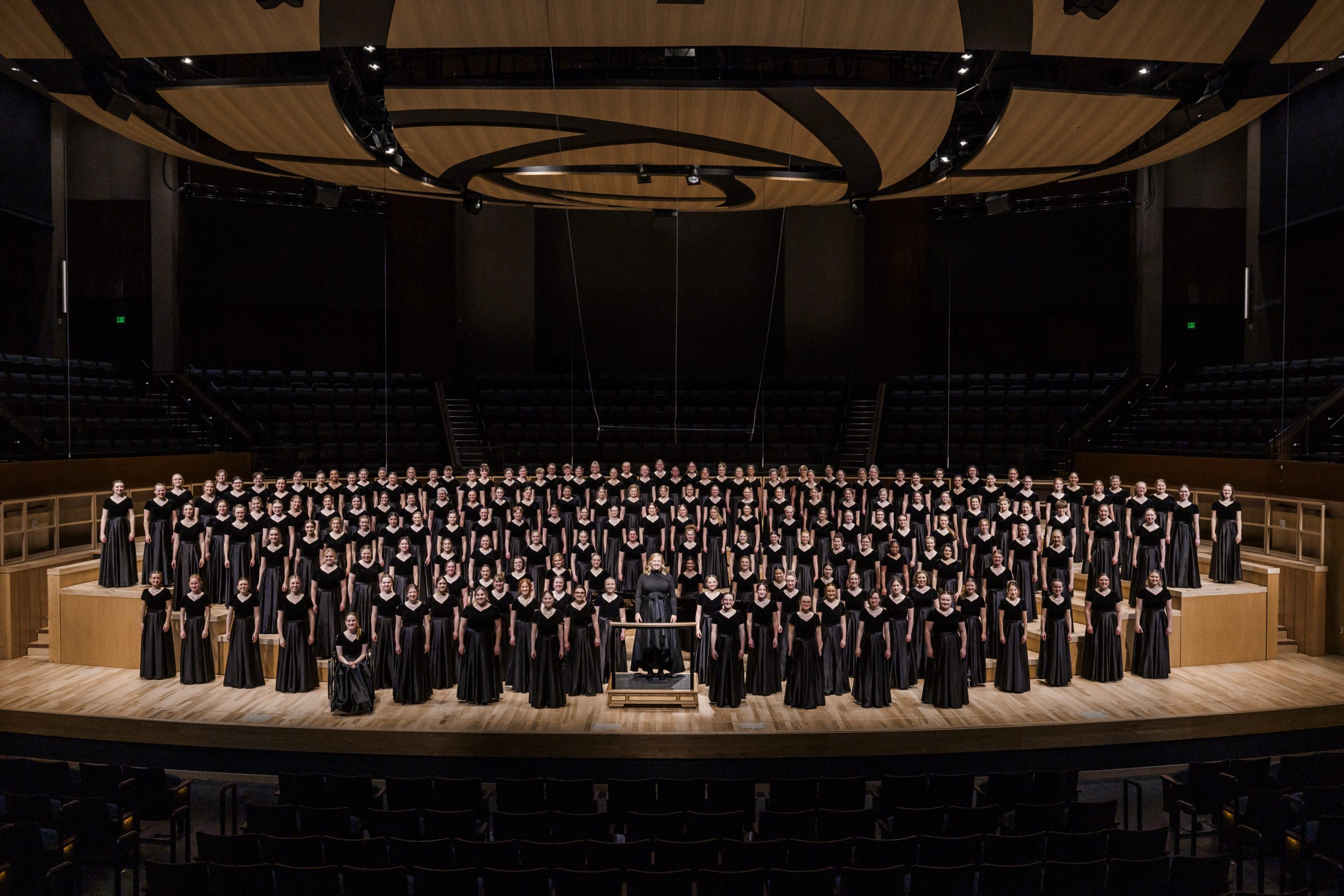 Women's Chorus stands in formation in concert black before a performance.