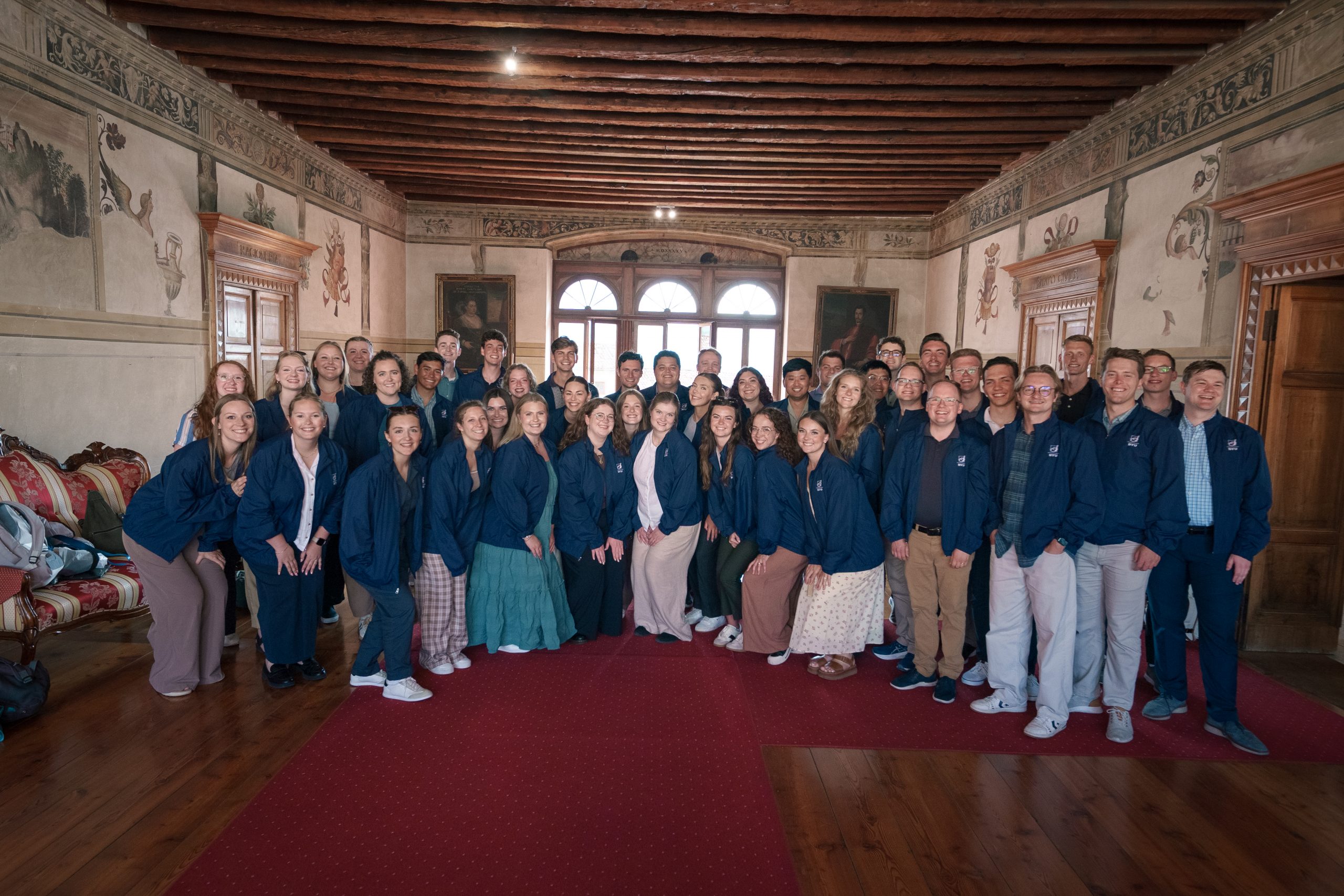 A group photo of the BYU Singers taken inside a beautiful building on their extended tour in Europe